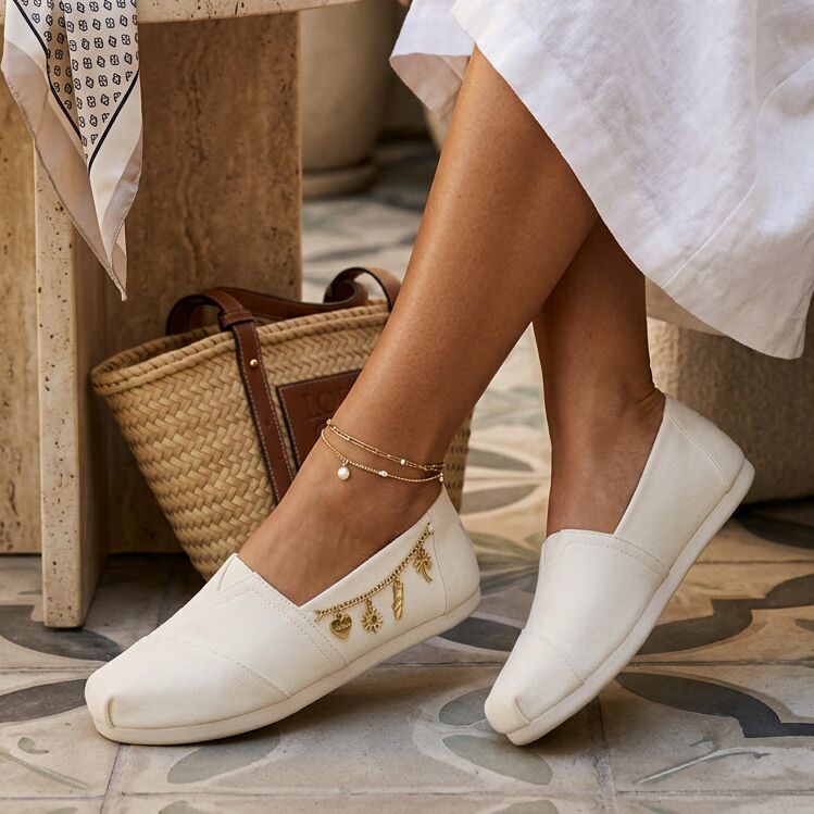 On model image of the white recycled cotton Alpargata with a gold filled charms side chain