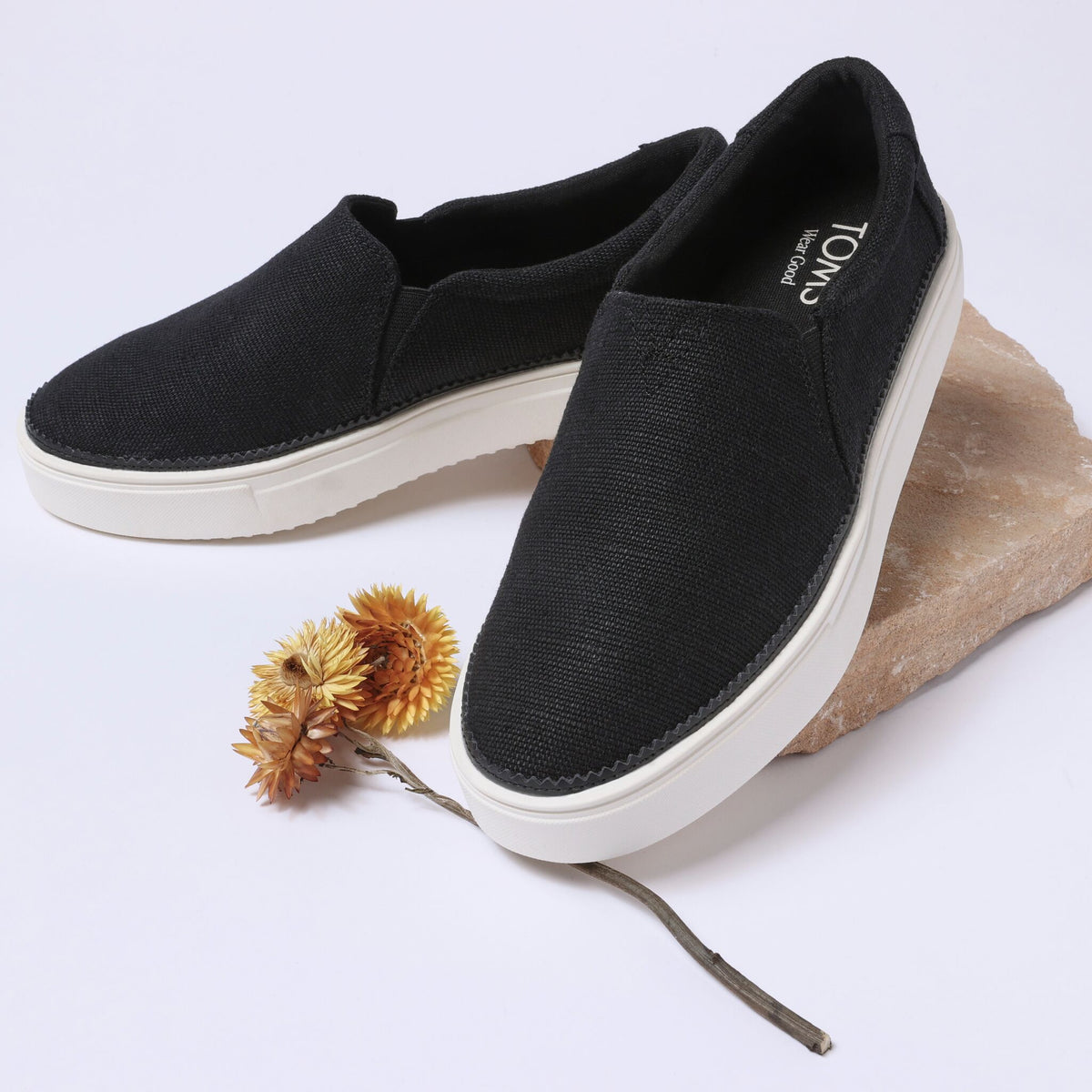 Laydown detail image of the black Emily slip on sneaker