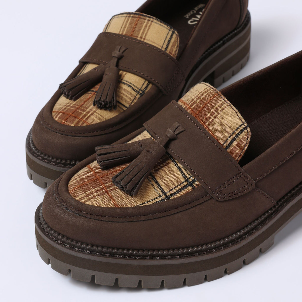 Up close detail image of the plaid Cara loafer with tassel detail
