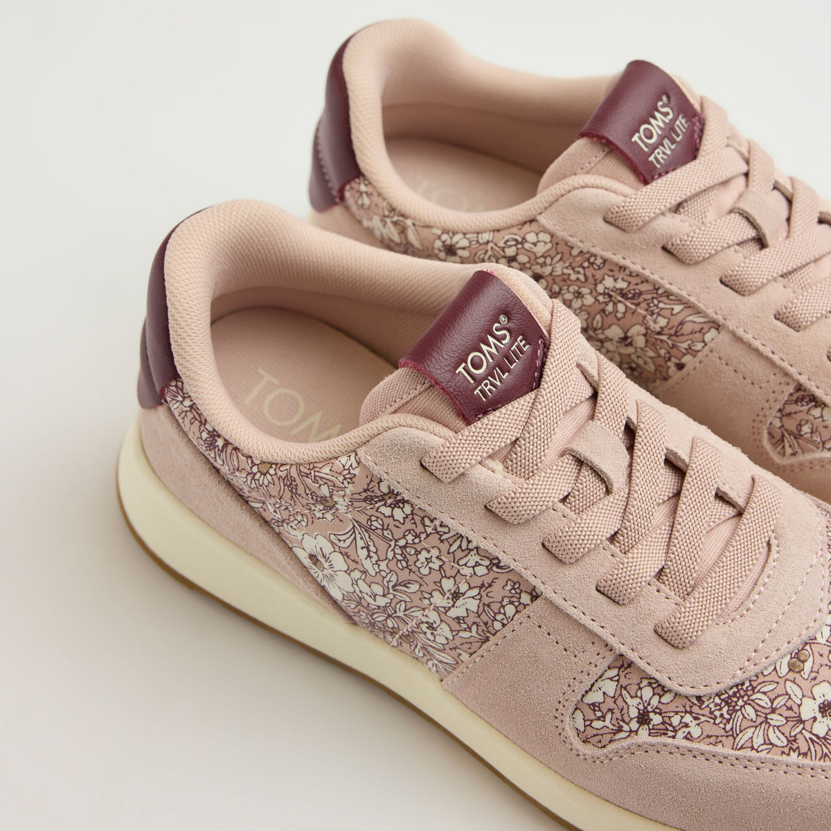 Laydown detail image of the burgundy and pink TRVL Lite retro sneaker