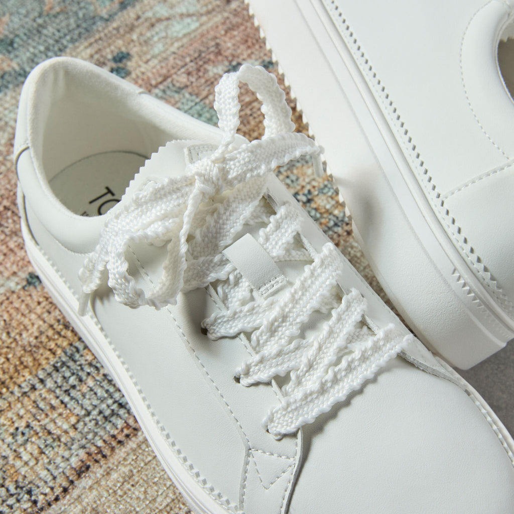 Laydown detail image of the white leather Izzy lace up sneaker